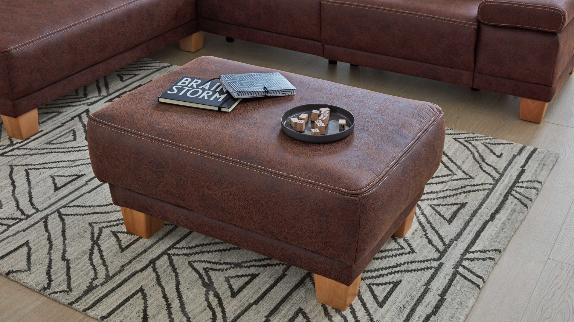 Polsterhocker Interliving aus Stoff in Dunkelbraun Interliving Sofa Serie 4252 – Polsterhocker schokobrauner Stoff Büffel & Buchenholzfüße – ca. 125 x 65 cm