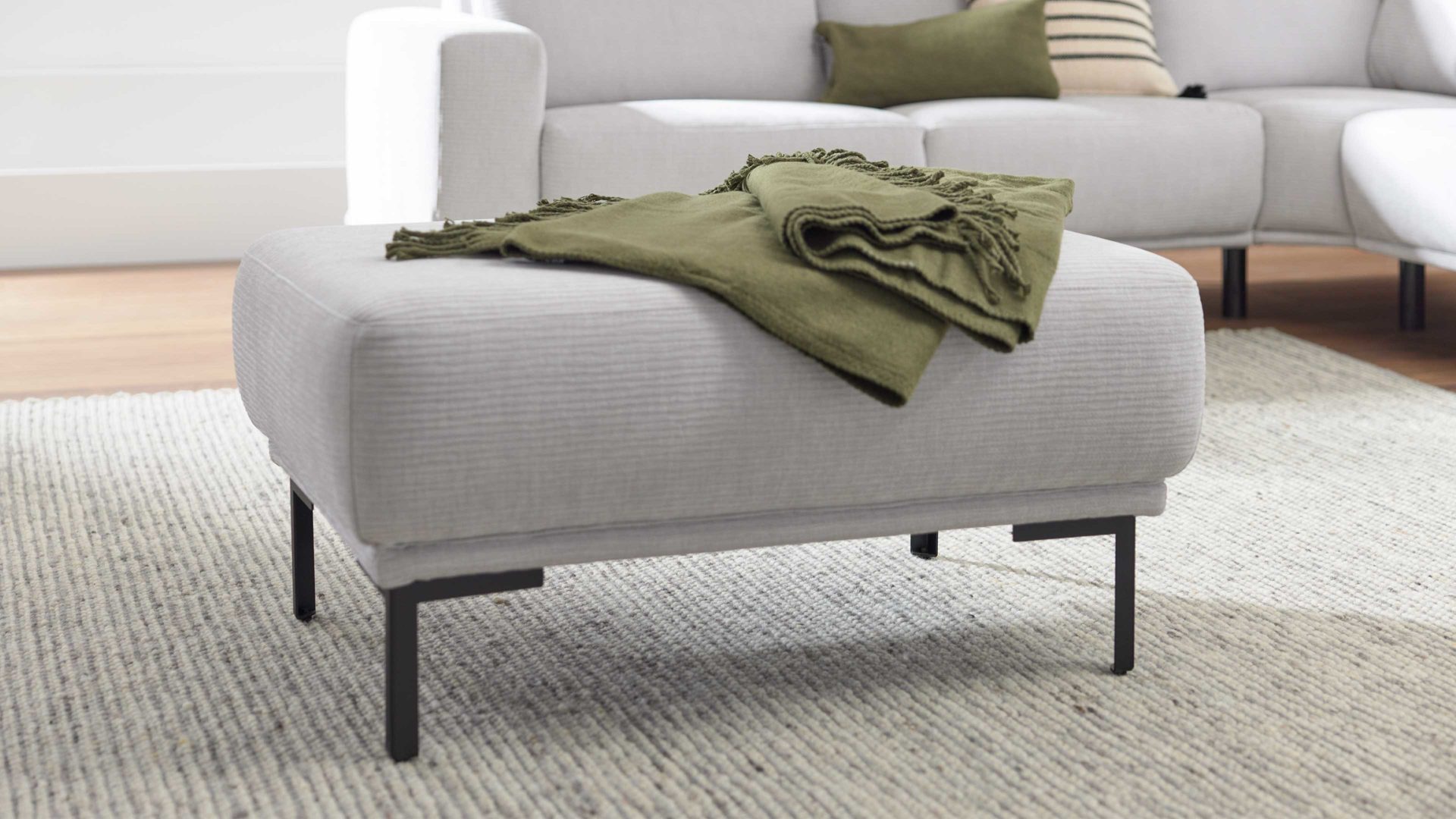 Polsterhocker Interliving aus Stoff in Hellgrau Interliving Sofa Serie 4255 – Polsterhocker silberfarbener Bezug Mara 9 & schwarze Metallfüße 4.26 - ca. 95 x 65 cm