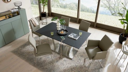 Tischgruppe Interliving aus Holz in Schwarz Interliving Esszimmer Serie 5122 – Essgruppe mit sechs Stühlen schwarzes Glas, fangofarbenes Kunstleder & Edelstahl