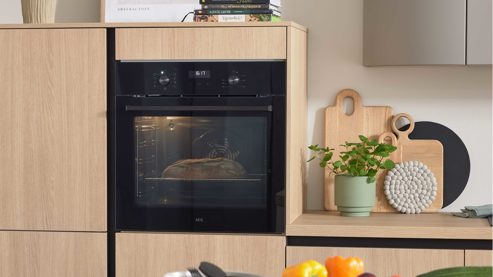 Einbauküche WERT KÜCHE® aus Holz in Grau WERT KÜCHE® Christin mit AEG Einbaugeräten Kaschmirbraun & Sandeiche – zweiteilig