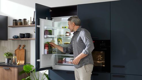 Einbauküche WERT KÜCHE® aus Holz in Blau WERT KÜCHE® Mona mit SIEMENS Einbaugeräten Bergamo Nussbaum & Tiefblau - dreiteilig