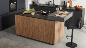 Einbauküche Interliving aus Holz in Schwarz Interliving Küche Serie 3076 mit Miele-Einbaugeräten Mattschwarz & Stripe Wood Choco - dreizeilig