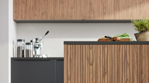 Einbauküche Interliving aus Holz in Schwarz Interliving Küche Serie 3108 mit Miele-Einbaugeräten Mattschwarz & Stripe Wood Choco - dreizeilig