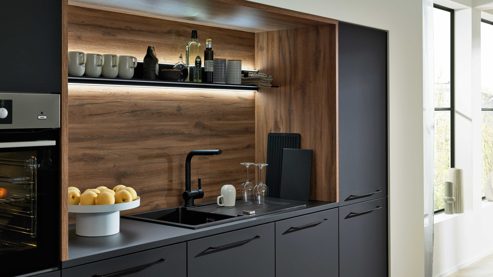Einbauküche Interliving aus Holz in Schwarz Interliving Küche Serie 3103 mit AEG Einbaugeräten Mattschwarz & Vulkaneiche  - dreizeilig