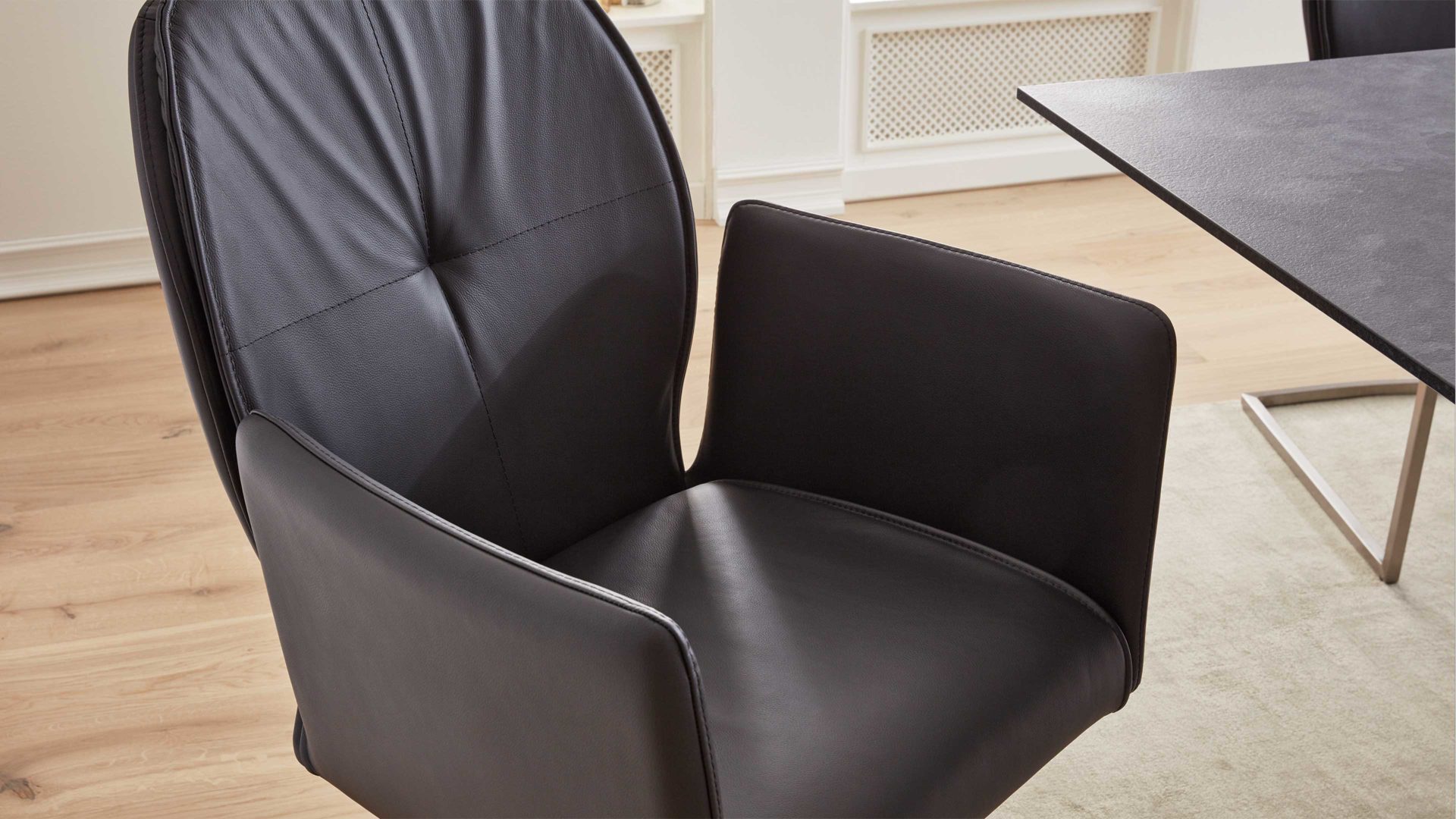 Vierfußstuhl Interliving aus Leder in Schwarz Interliving Esszimmer Serie 5104 – Armlehnstuhl schwarzes Leder Raven & Edelstahlgestell