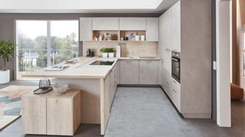 Einbauküche Nobilia® aus Holz in Holzfarben Hell nobilia® Einbauküche Riva mit JUNKER Elektrogeräten und Esstheke Beton Sand & Eiche Montreal - Stellfläche ca. 304 x 319 cm