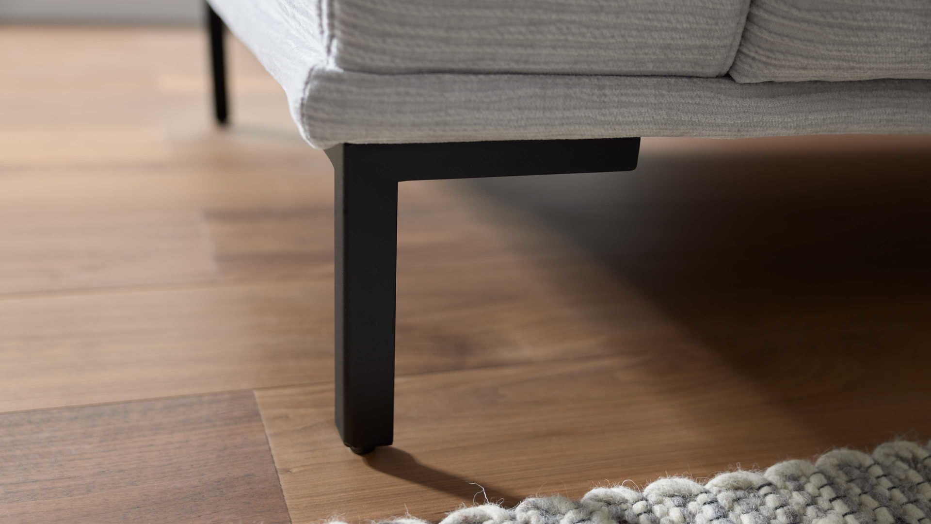 Polsterhocker Interliving aus Stoff in Hellgrau Interliving Sofa Serie 4255 – Polsterhocker silberfarbener Bezug Mara 9 & schwarze Metallfüße 4.26 - ca. 95 x 65 cm