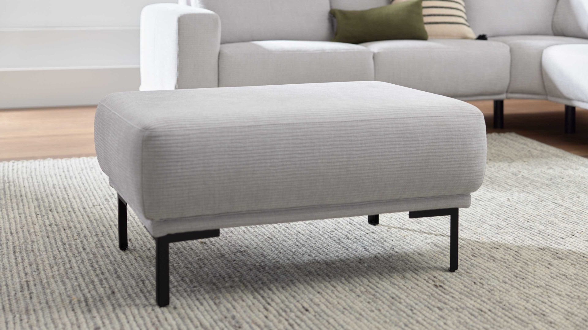 Polsterhocker Interliving aus Stoff in Hellgrau Interliving Sofa Serie 4255 – Polsterhocker silberfarbener Bezug Mara 9 & schwarze Metallfüße 4.26 - ca. 95 x 65 cm