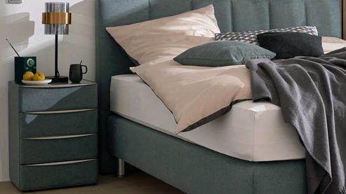 Nachtkommode Interliving aus Holz in Blau Interliving Boxspringbett Serie 1402 – Nachtkommode stahlfarbene Mikrofaser Nele  – vier Schubladen
