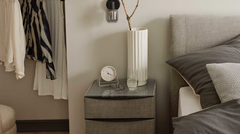 Nachtkommode Interliving aus Holz in Grau Interliving Boxspringbett Serie 1401 – Nachtkommode silberfarbener Stoffbezug Rob 533006 – vier Schubladen